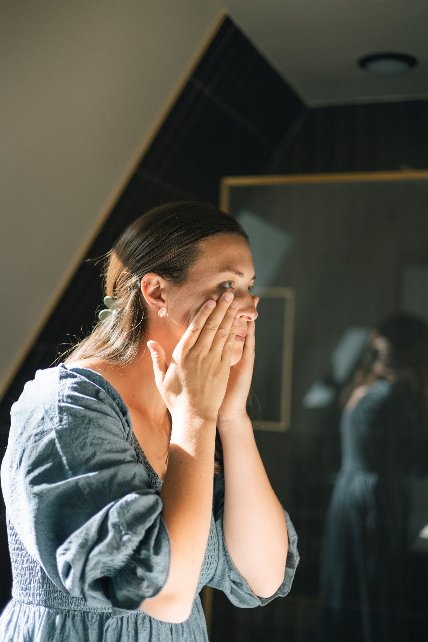 A woman applies Brighten Vitamin C serum to her face.