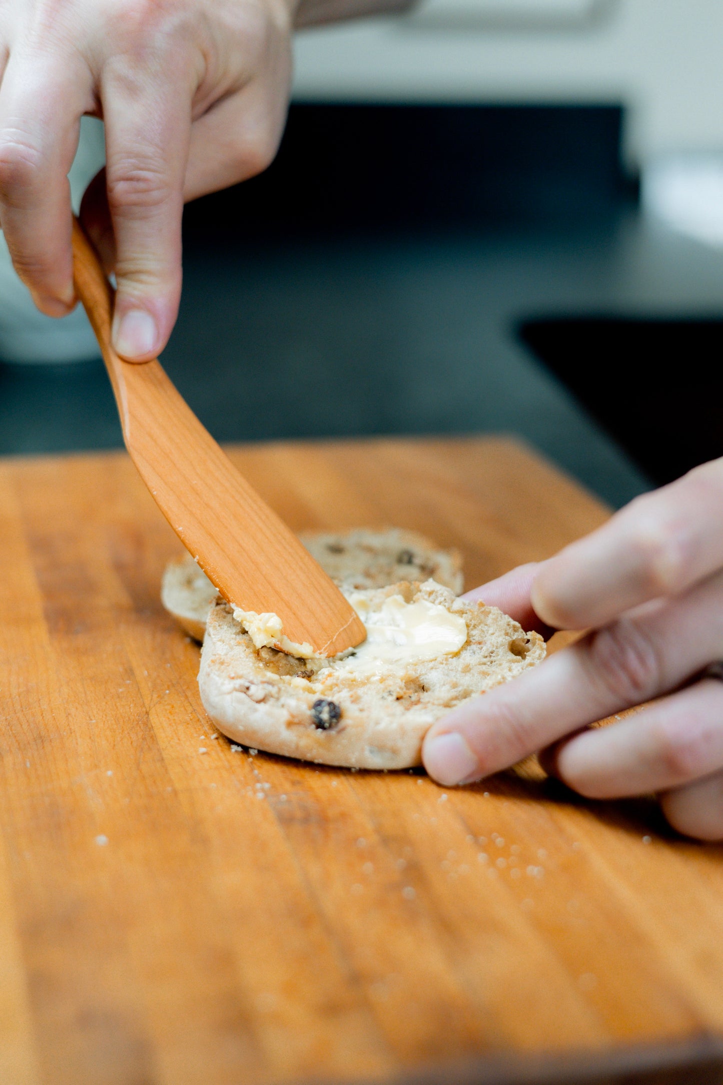 Spreading butter with cherry wood spreader knife.