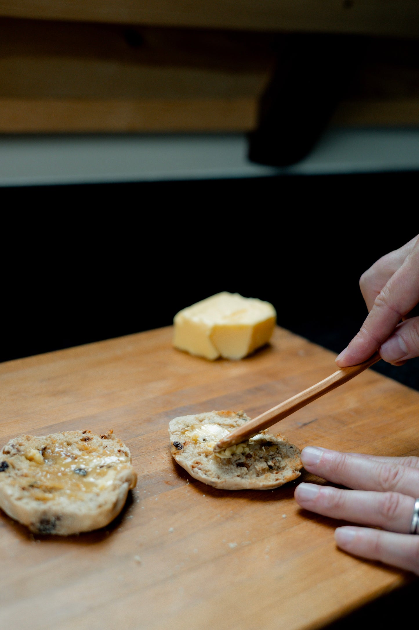 Spreading butter on english muffin with cherry wood spreader knife.