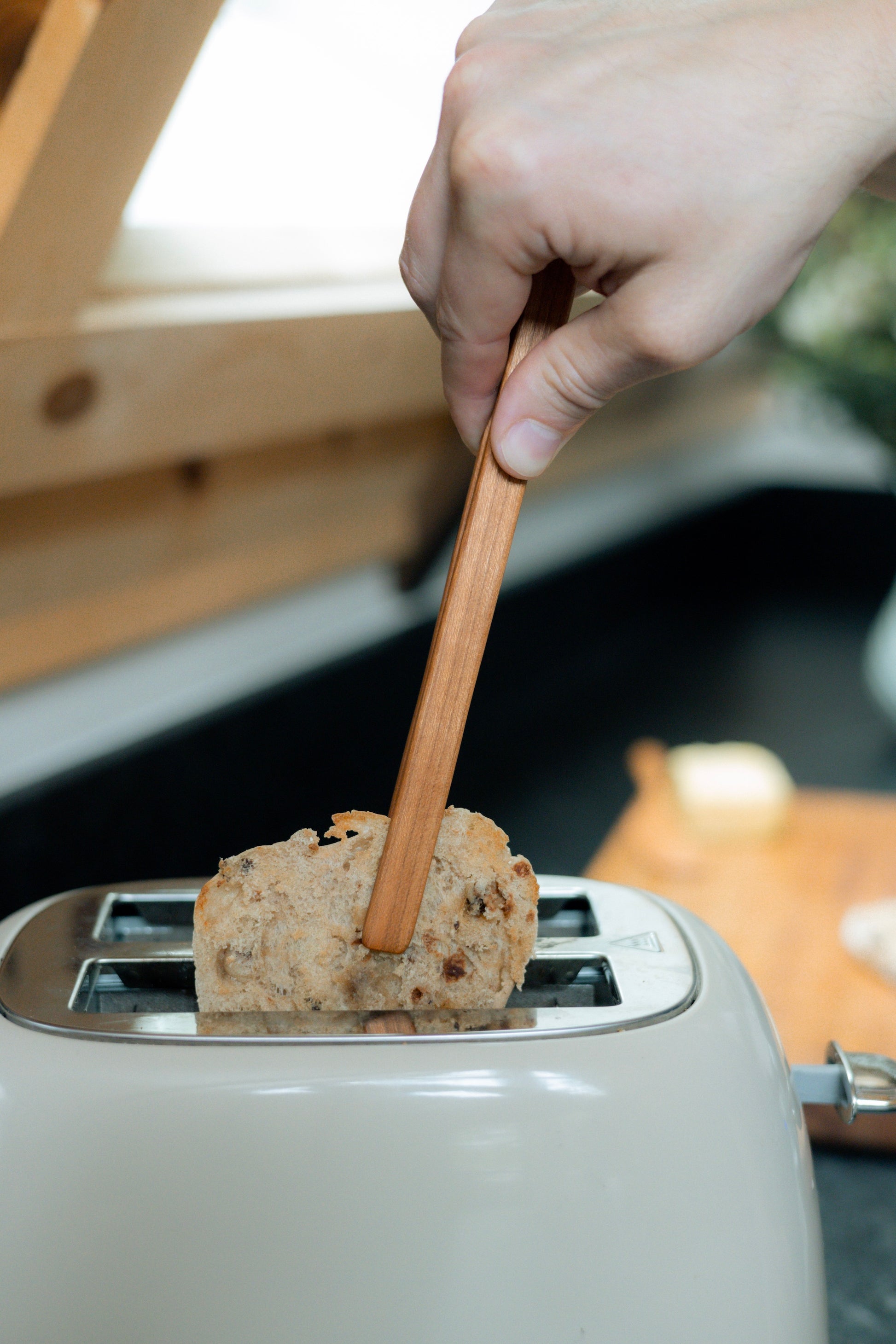 Removing english muffin using cherry wood tongs.