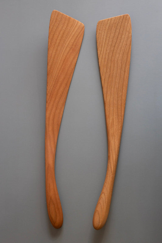 two wooden spatulas on a grey background