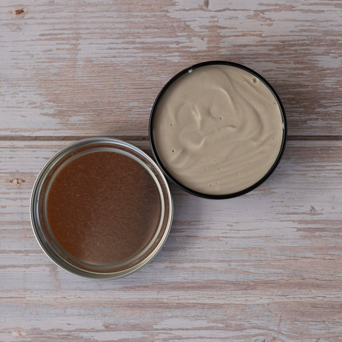 Open tin of tallow hair clay on a wooden background.