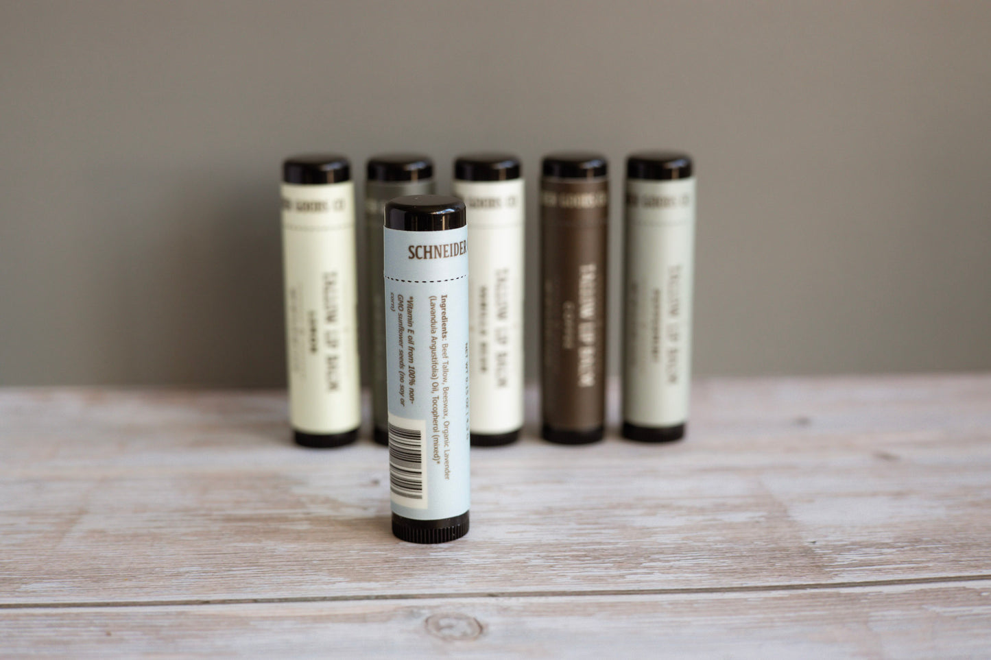 set of tallow lip balm tubes on a wooden surface