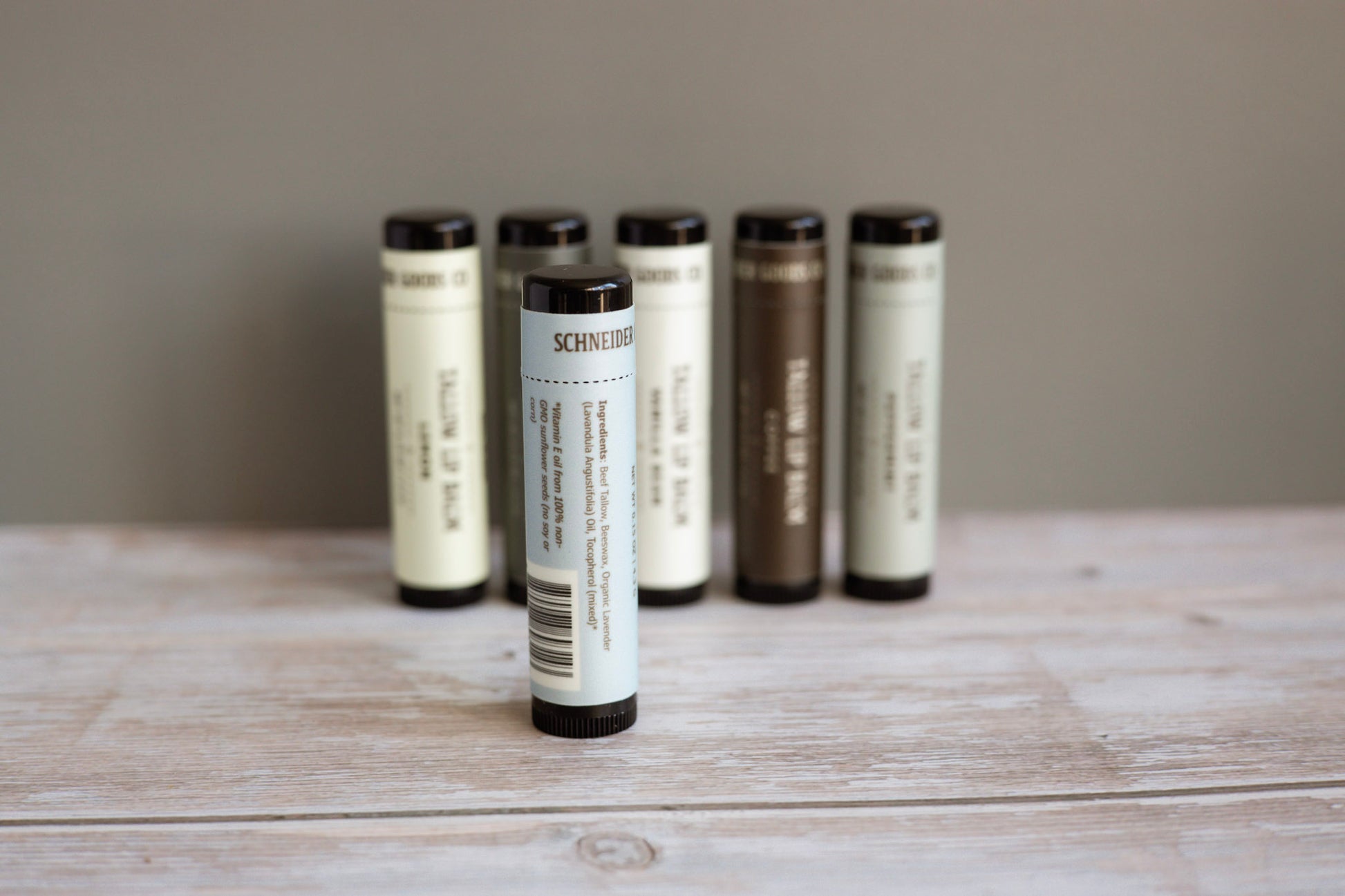 set of tallow lip balm tubes on a wooden surface